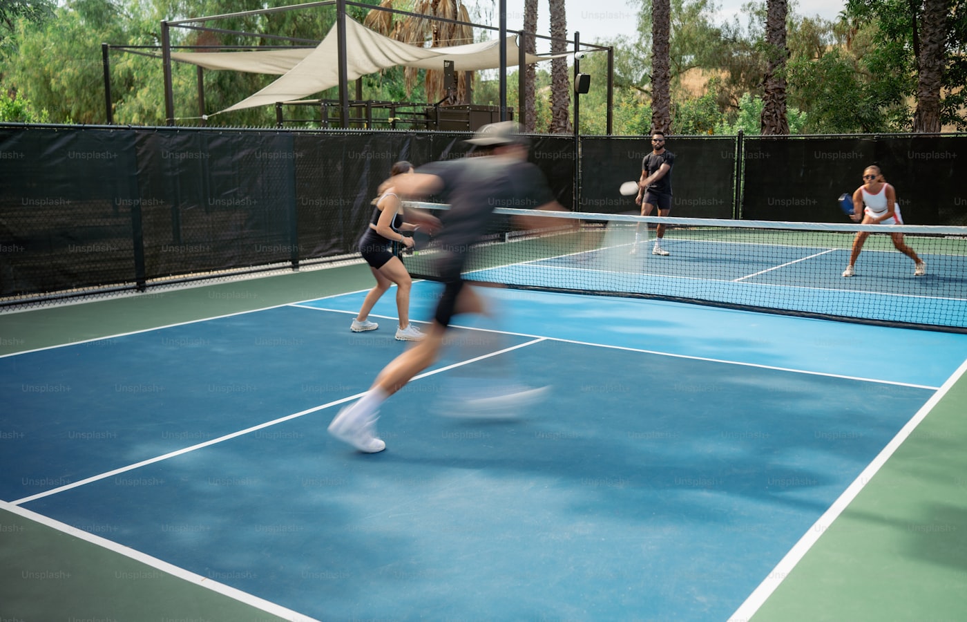 Players in action on an outdoor pickleball court